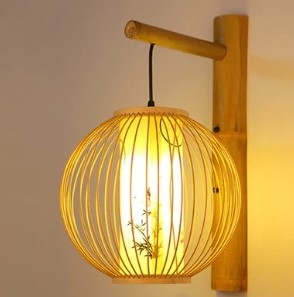 Cette applique en rotin est ronde et avec des motifs asiatiques. La structure est en bois et elle est fixée à un mur beige.