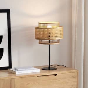 Lampe en rotin, couleur naturelle, sur commode en bois avec des cadres