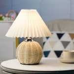 Lampe de chevet en rotin blanche posée sur une table dans une chambre