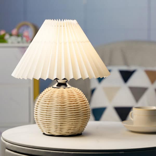 Lampe de chevet en rotin blanche posée sur une table dans une chambre