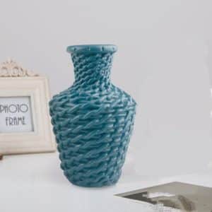 Petit vase en rotin style moderne, placé sur une table.