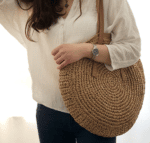 Très joli sac de plage, cabas tissé porté par une femme élégante brune.