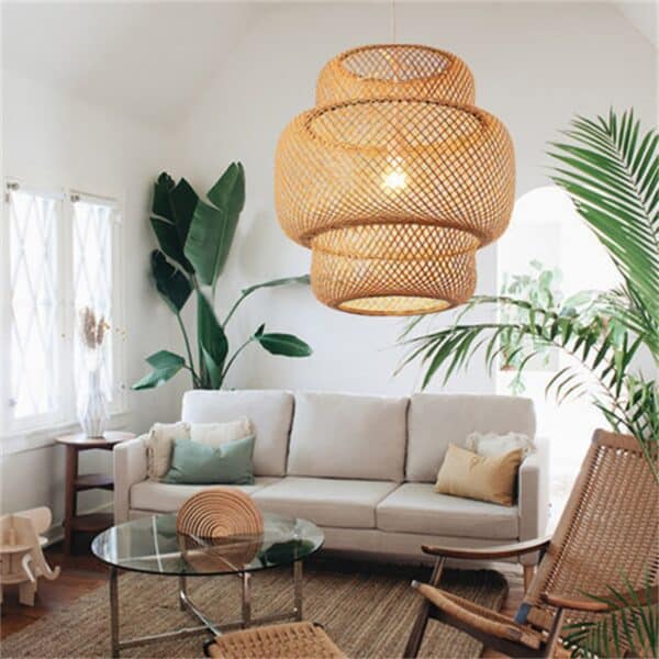 Plafonnier en bambou tissé à la main, design art moderne, dans un salon meublé avec canapé gris, plantes verte, tapis