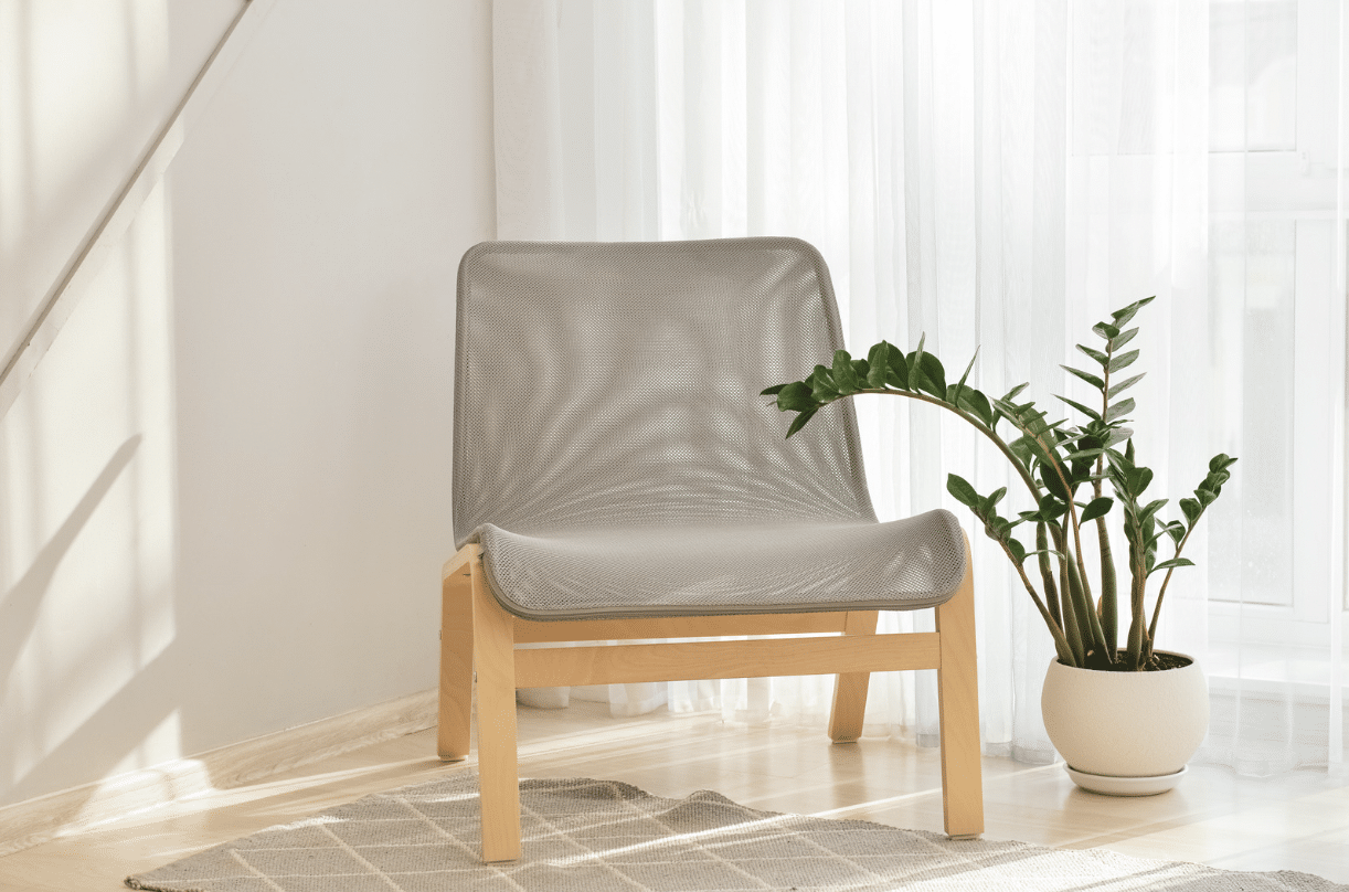 fauteuil en rotin devant une fenêtre avec une plante