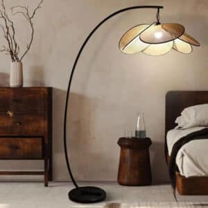 Lampadaire Rotin LED avec Pétales dans une pièce avec un mur gris et un lit à droite