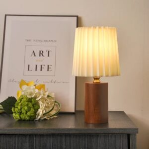 Lampe de Chevet Bois Moderne et Élégante posé sur une table marron avec cadre et fleurs à côté