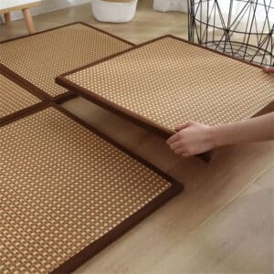 Tapis Rotin Carré Style Japonais dans la main d'une personne sur fodn beige